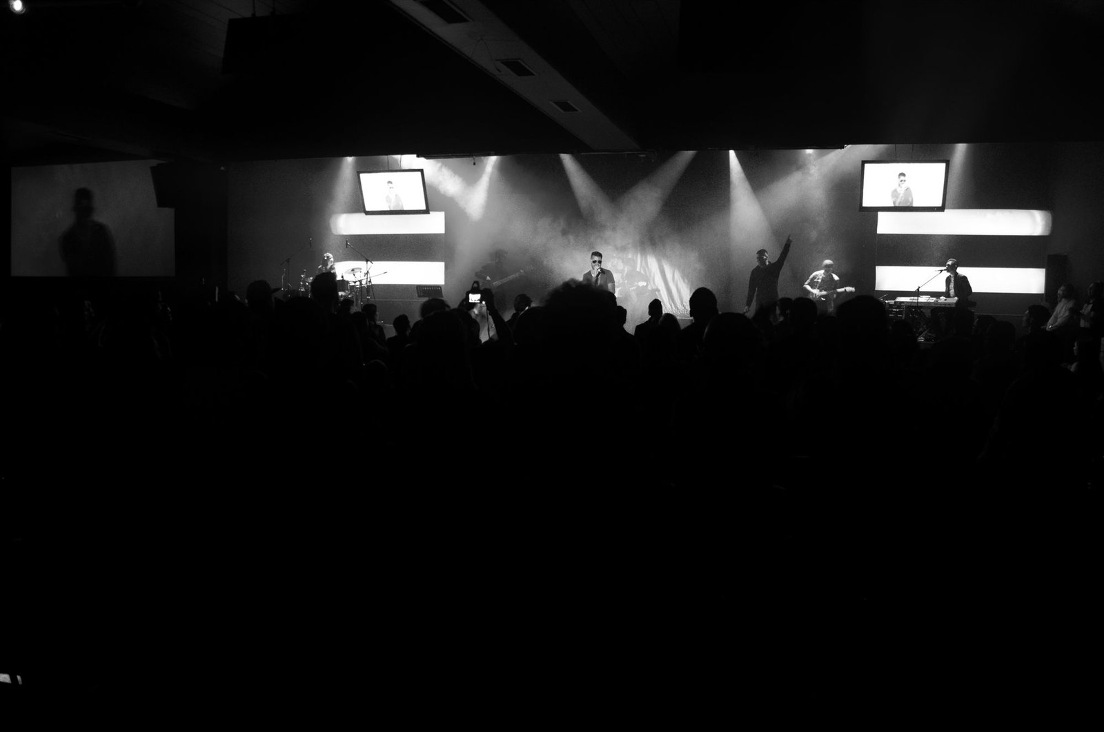 Jembo D. en concierto con banda y público, blanco y negro